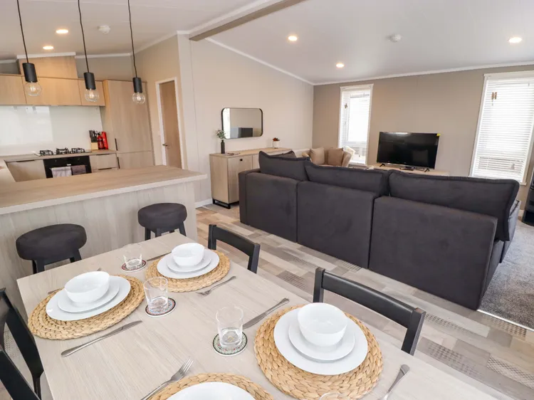 Dining area with breakfast bar in the open-plan kitchen/diner at Awel y Môr (Dolphin)