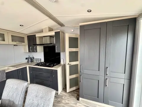Kitchen storage and integrated appliances at Tŷ'r Môr holiday lodge
