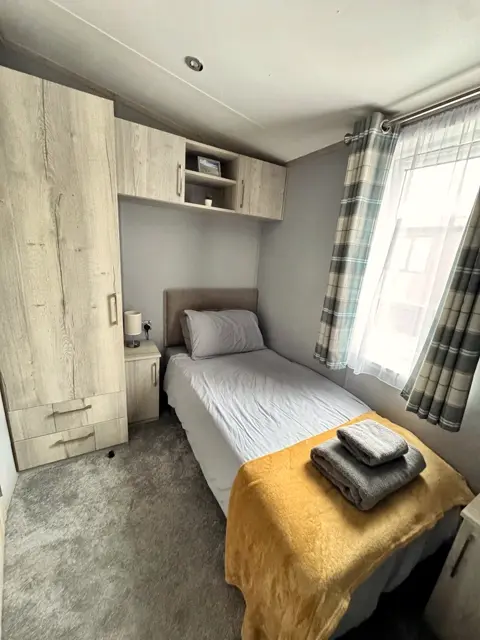 Single bed and wardrobe in the twin bedroom at Tŷ'r Môr