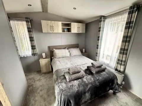 Main bedroom at Tŷ'r Môr with king-size bed, bedside storage and overhead cupboards