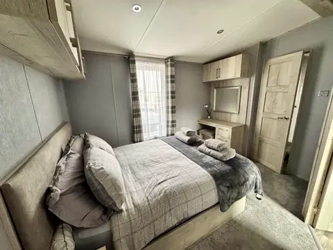 Cushioned king-size bed and window seat detail in the main bedroom at Tŷ'r Môr