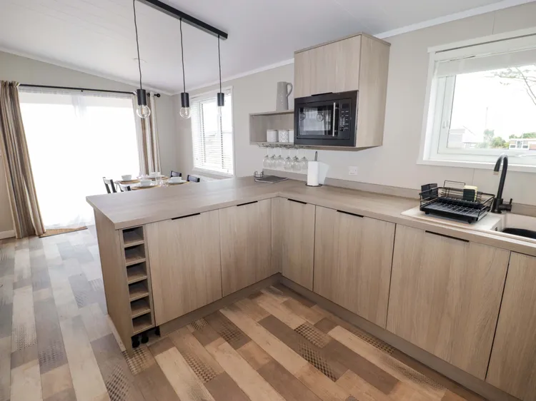 Fully equipped kitchen with oven, gas hob, microwave, fridge/freezer and dishwasher at Awel y Môr (Dolphin)