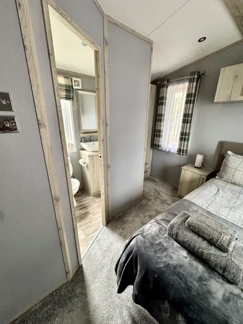 Main bedroom at Tŷ'r Môr with dressing table and Jack-and-Jill shower room beyond
