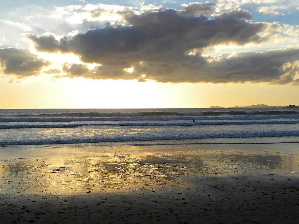 Surf rolling onto the two-mile sandy beach and pebble bank at Newgale
