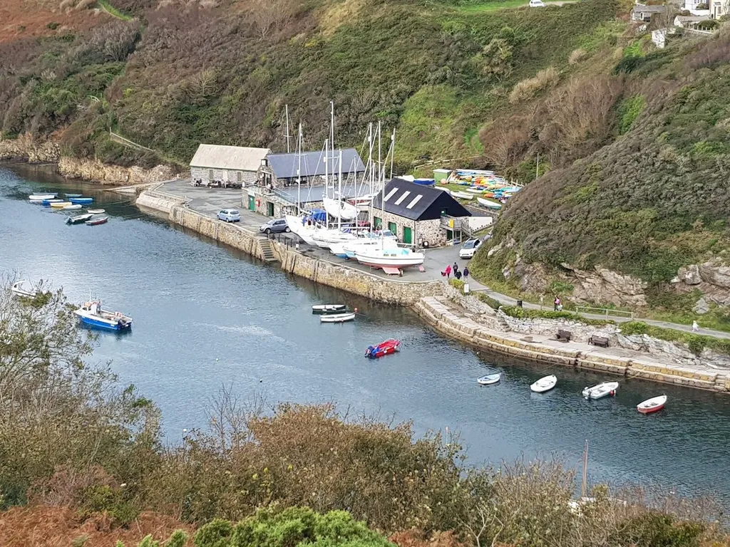 Boats in the tidal harbour at Solva surrounded by green valley slopes